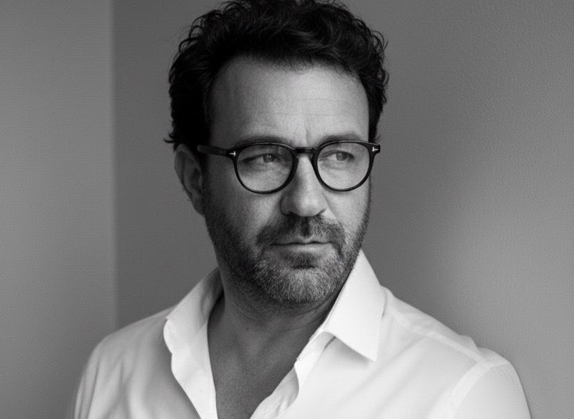 Retrato en blanco y negro de Juan Vinaches, con gafas y camisa blanca